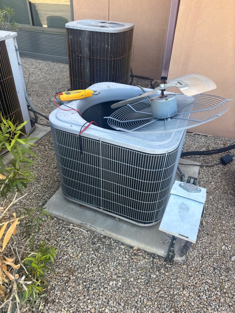 A technician repairing a condenser with its fan removed