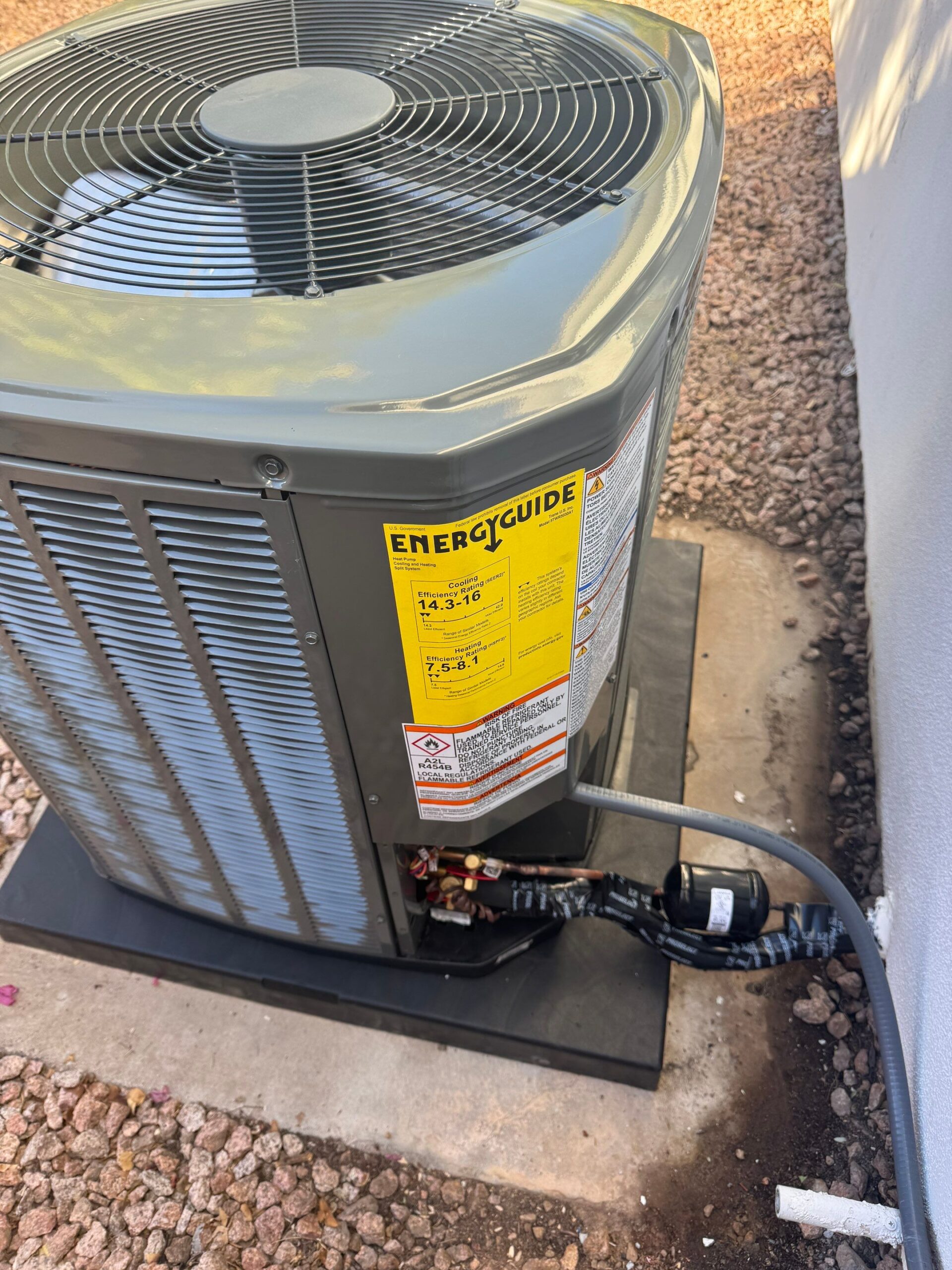 A newly installed outdoor condenser unit beside a home