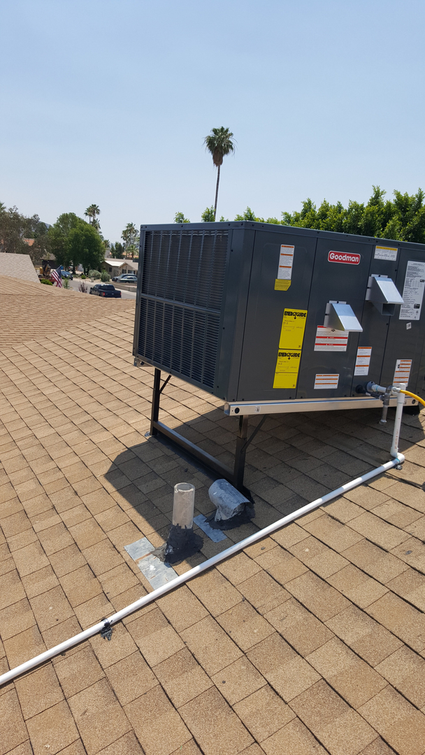 A packaged rooftop HVAC unit installed on a shingled roof