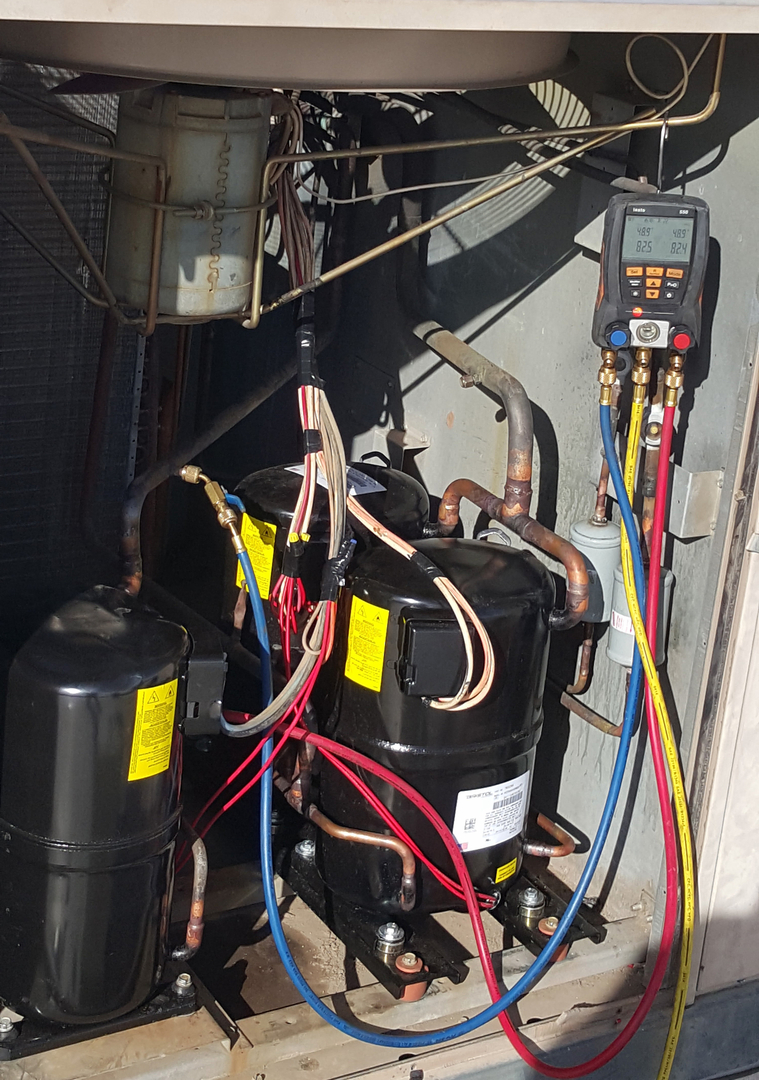 A compressor with a digital manifold gauge set connected for diagnostics